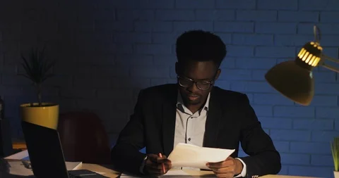 Stressed businessman confused by mistake in documents working at desk in night Stock Footage 108372003