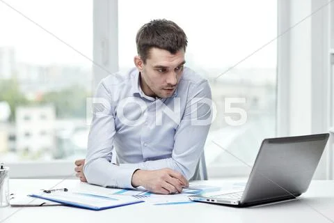 Stressed businessman with laptop at office Stock Photos