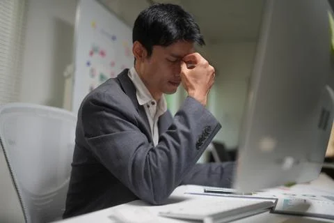Stressed businessman working at office computer Stock Photos