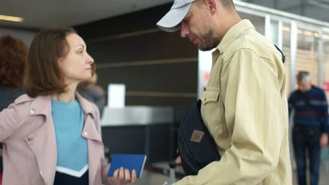 Stressed couple looking at the boarding pass checking the departure time in Stock Footage 121378997