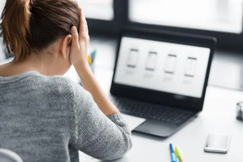 Stressed designer with user interface on laptop 스톡 사진