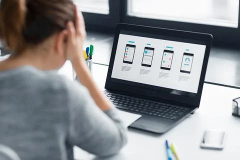 Stressed designer with user interface on laptop Stock Photos