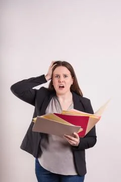 Stressed expression on young womens face holding scattered paper Stock Photos