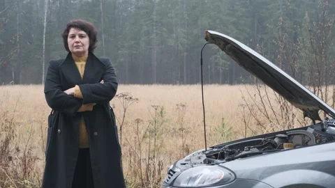 Stressed female driver standing of open hood and looking. Breakage, problem. Stock Footage 144064288