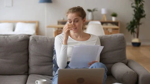 Stressed girl student feeling worried reading bad news in papers Stock Footage