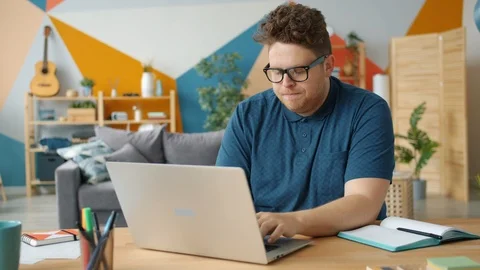 Stressed guy freelance worker is using laptop typing feeling tired and unhappy Stock Footage