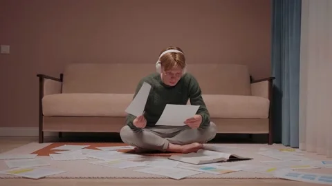 Stressed guy sits on the floor full of papers and gives up, leaning on couch Video stock 164381281