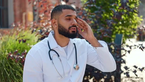 Stressed indian physician having rest on fresh air to get rid of strong headache Video stock 250076642