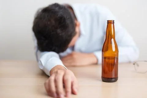 Stressed man drinking beer alone with problem. Exhausted drunk man looking .. Stock Photos
