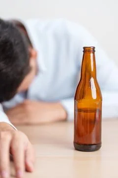 Stressed man drinking beer alone with problem. Exhausted drunk man looking .. Stock Photos