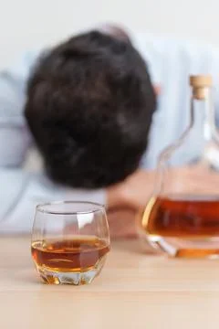 Stressed man drinking cognac alone with problem. Exhausted drunk man lookin.. Foto stock