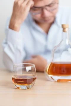 Stressed man drinking cognac alone with problem. Exhausted drunk man lookin.. Foto stock