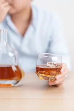 Stressed man drinking cognac alone with problem. Exhausted drunk man lookin.. Foto stock