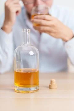 Stressed man drinking whiskey alone with problem. Exhausted drunk man looki.. Stock Photos