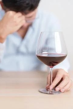 Stressed man drinking Wine alone with problem. Exhausted drunk man looking .. Stock Photos
