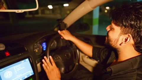 Stressed man drives slowly inside underground parking Stock Footage 310285174