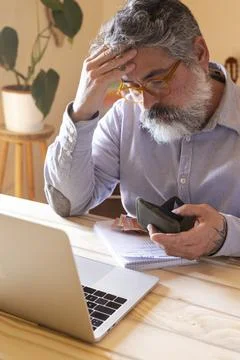 Stressed man experiencing financial problems holding empty wallet 스톡 사진