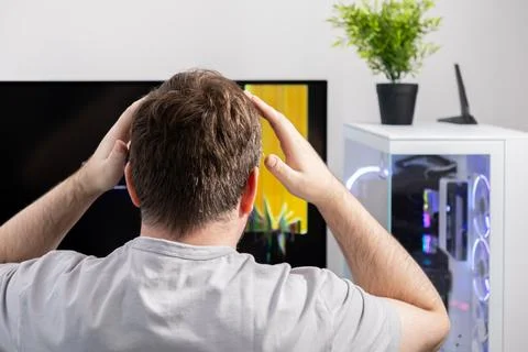 Stressed man with hands on head, facing computer error, representing techni.. Stock Photos