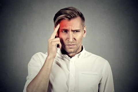 Stressed man with headache touching head temple colored in red Stock Photos
