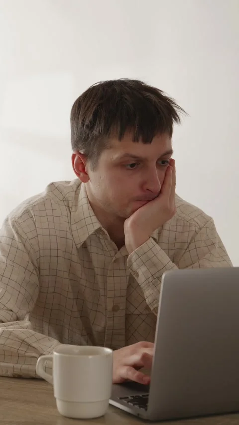 Stressed man holding hand on head looking at laptop screen in disbelief Stock Footage 335082359