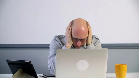 Stressed man holding hands on head while looking at laptop Video stock 130460908