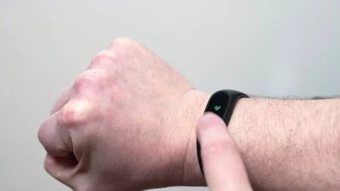 A stressed man measures his pulse with a fitness bracelet on his shaky hand. Stock Footage 251856073