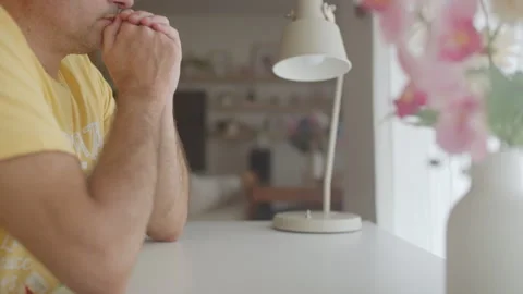 Stressed man placing glasses on table at home Stock Footage 345985485