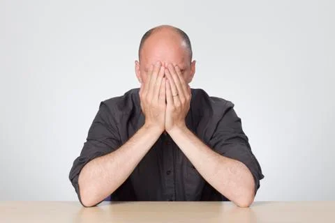 Stressed man sitting at empty desk Stock Photos