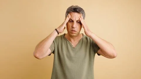 Stressed man suffering from headache experiencing migraine pain Stock Photos