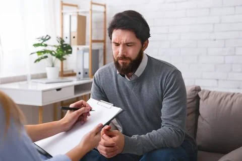Stressed man talking to psychologist, solving his personal problems Foto stock
