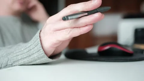 Stressed man tapping pen on desk during tedious work Stock Footage 344527898