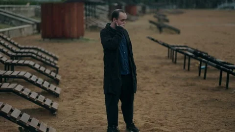 Stressed Man Walks Alone by the Beach, Lost in Thought and Emotion Stock Footage 313605640