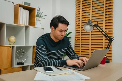 Stressed man working with laptop computer at home office Stock Photos