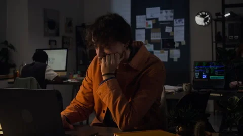 Stressed Man Working Late on Laptop Experiencing Burnout in Office Stock Footage 338417056