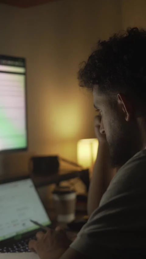Stressed man working late at night on laptop in a dimly lit room Stock Footage 327307703