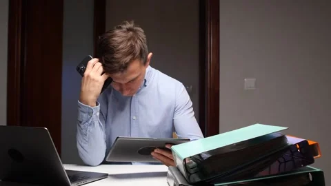 Stressed man working overtime multitasking with multiple devices Stock Footage 322912423