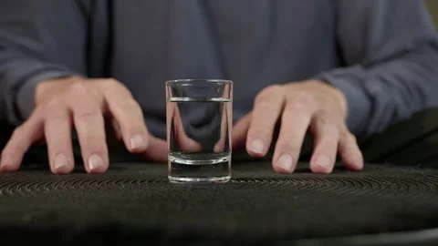 Stressed man's hands tensing around a shot glass of alcohol Stock Footage 334744691