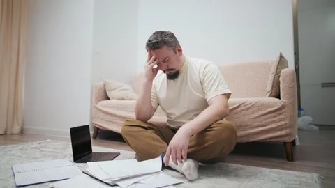 Stressed middle-aged man suffering from a headache at home Видео 328034323