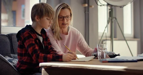 Stressed Mother helps son doing homework Stock Footage 128674430