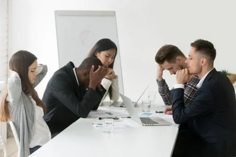 Stressed multiracial team thinking of problem solution at group Stock Photos