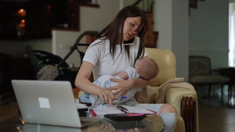 Stressed multitasking mother working from home holding a baby Stock-Footage 331303172