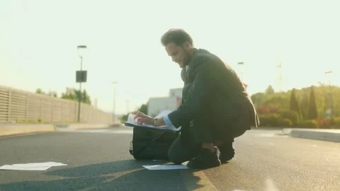 Stressed office worker picks up dropped papers on urban street Stock Footage 312878486