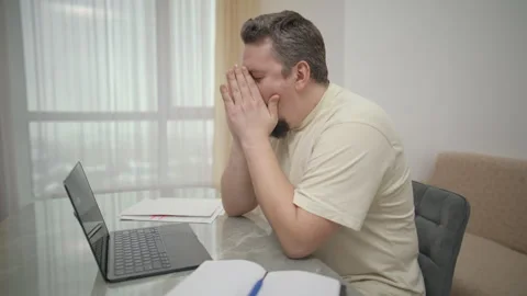 Stressed overworked man feeling tired working on laptop at home Stock Footage 340925715