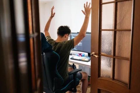 Stressed programmer slumping in gaming chair, head buried in hands, experiencing Stock Photos