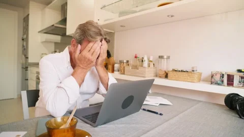 Stressed retired man feeling frustrated using a laptop at home Stock Footage 343218622