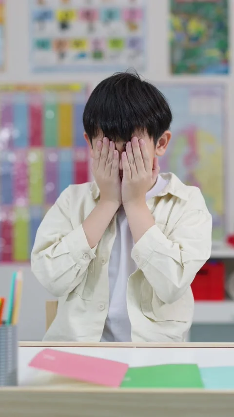 Stressed Schoolboy Covering Face in Classroom During Schoolwork Stock Footage 326386078