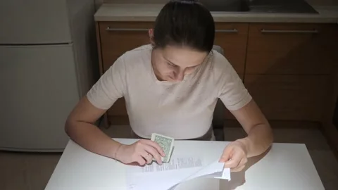 Stressed woman having financial problems sitting on kitchen and reading tax Video stock 166174792