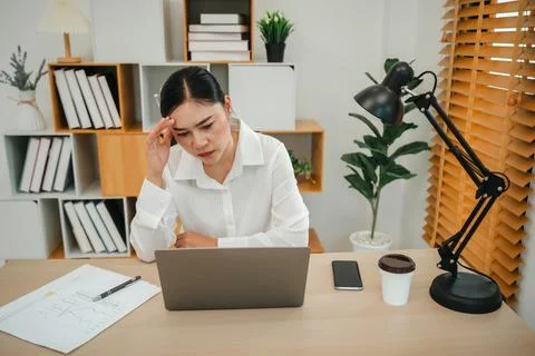Stressed woman headache while working with laptop computer at home office Stock Photos