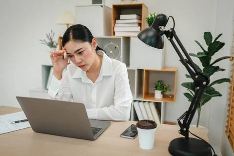 Stressed woman headache while working with laptop computer at home office Stock Photos