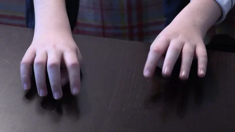 Stressed young boy tapping his fingers on wooden table Stock Footage 86263705